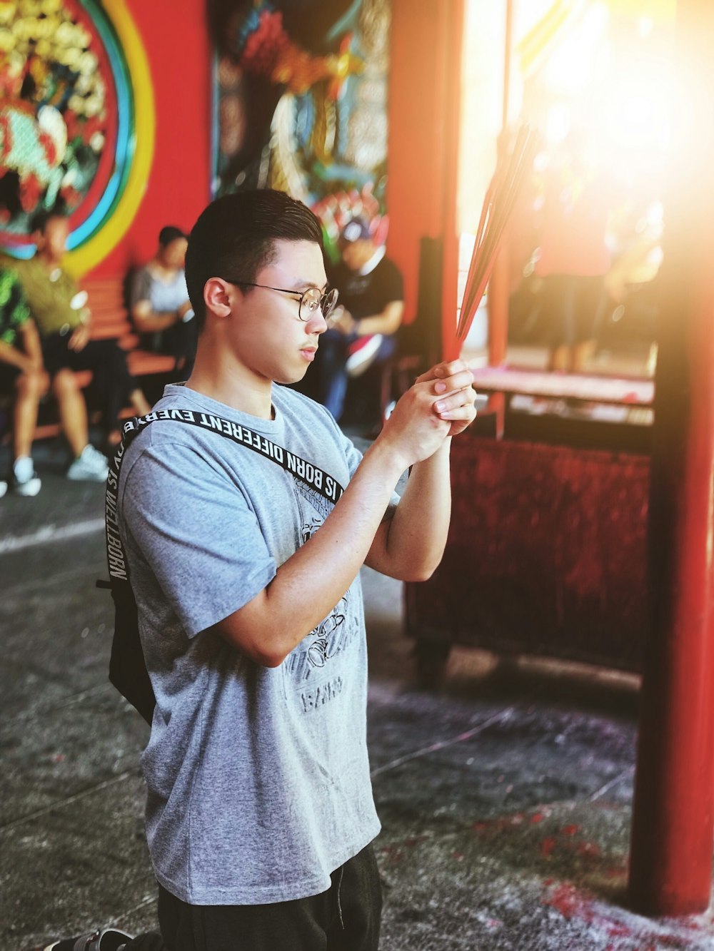 man holding incense sticks