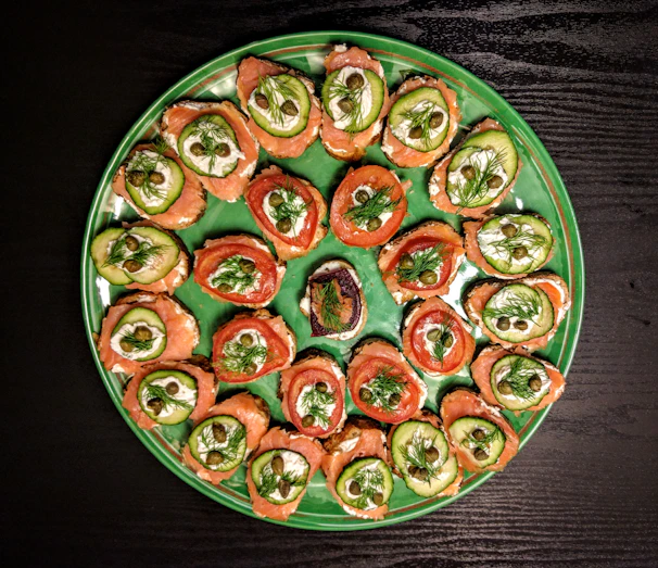 A beautifully arranged platter of Russian appetizers including pirozhki, smoked salmon, and fresh dill garnish.