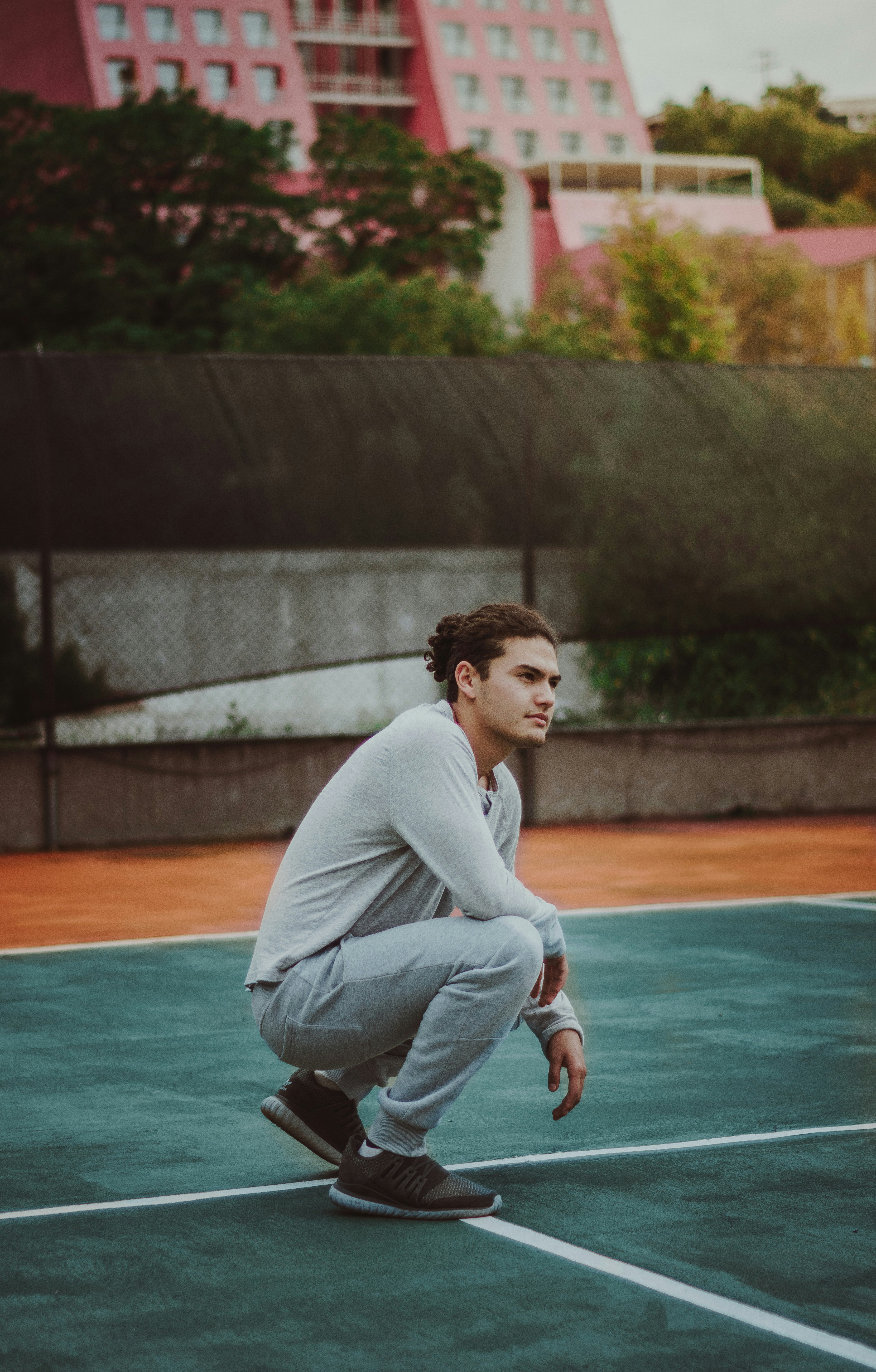 日中コートにしゃがむ男の写真 Unsplashの無料人写真