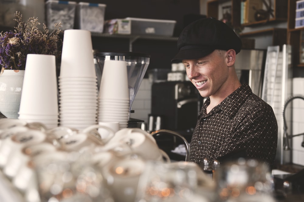 hombre sonriente junto a las tazas