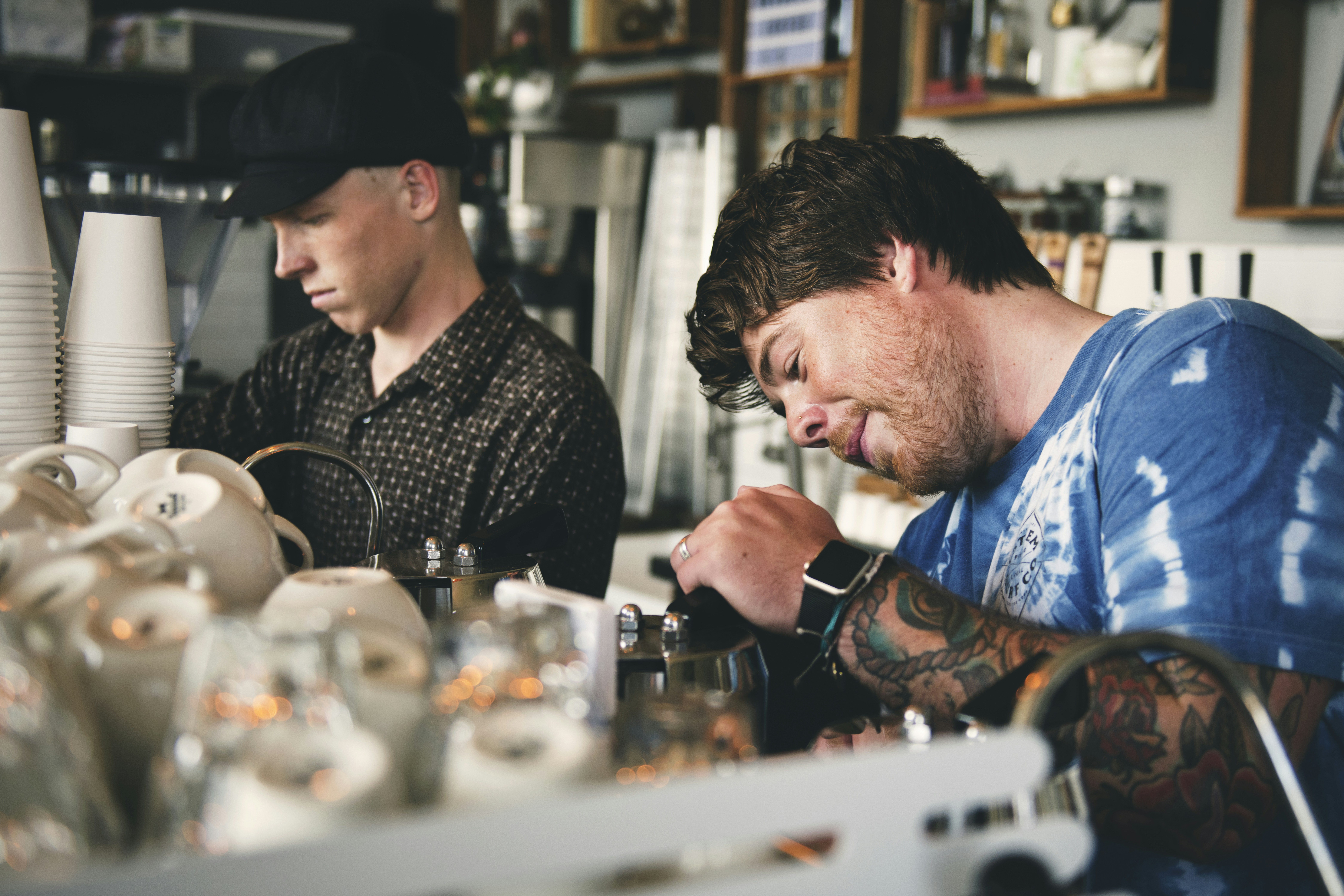 Two baristas making coffee at a crowded counter