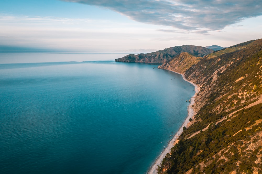 aerial photography of mountain beside blue ocean