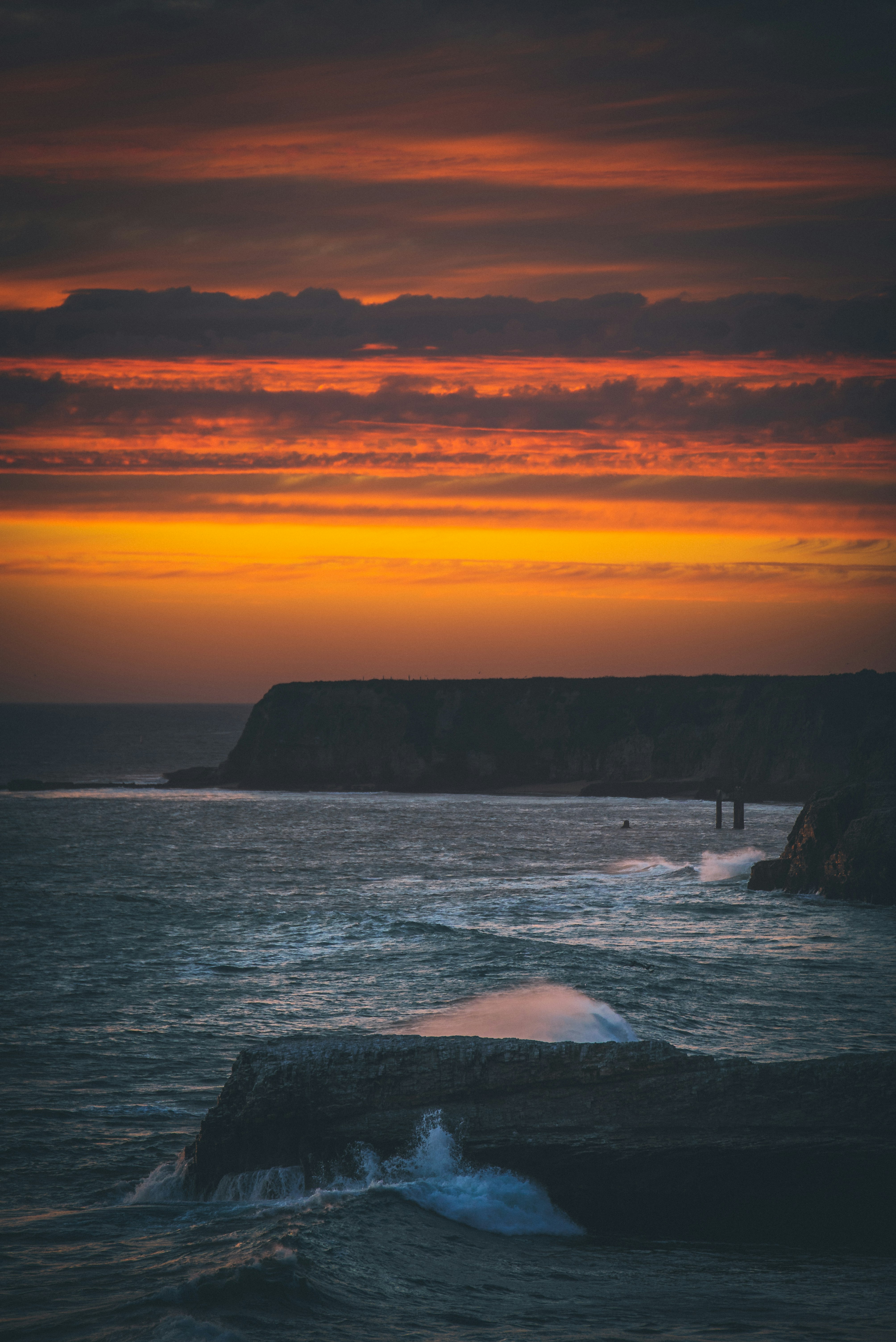 brown mountain beside sea during golden hour