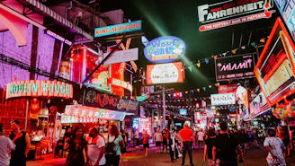 people standing between store buildings at nighttime