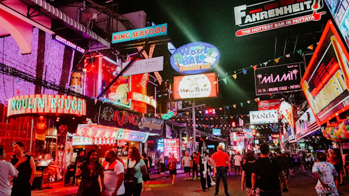 people standing between store buildings at nighttime