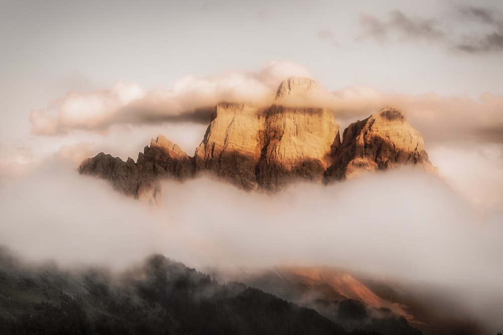 clouds covering rock mountain