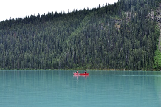 red canoe on calm body of water in Joffre Lakes Provincial Park Canada