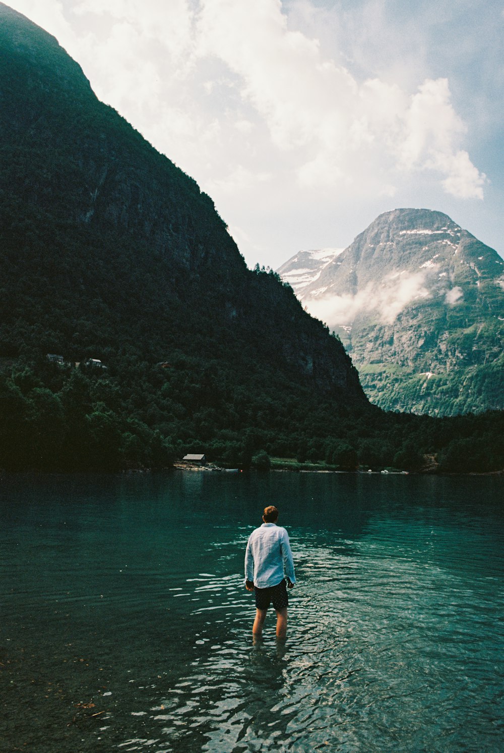 man wearing white dress shirt standing in lake