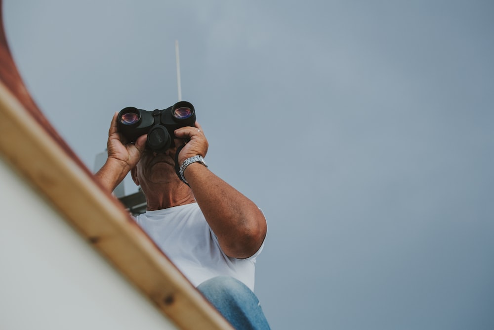 man holding black binoculars