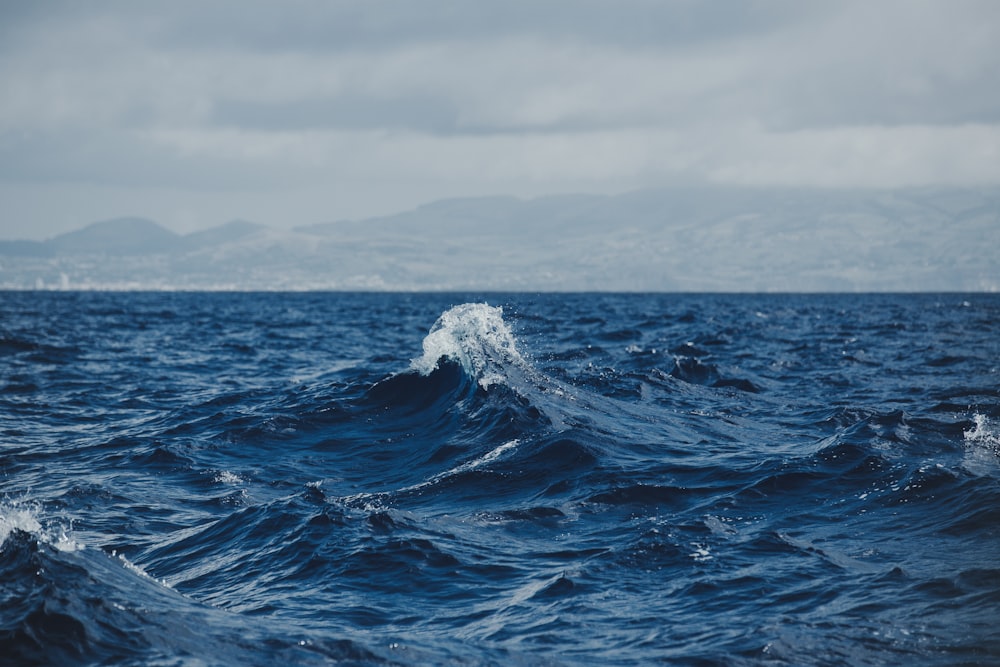 ocean wave under gray sky at daytime