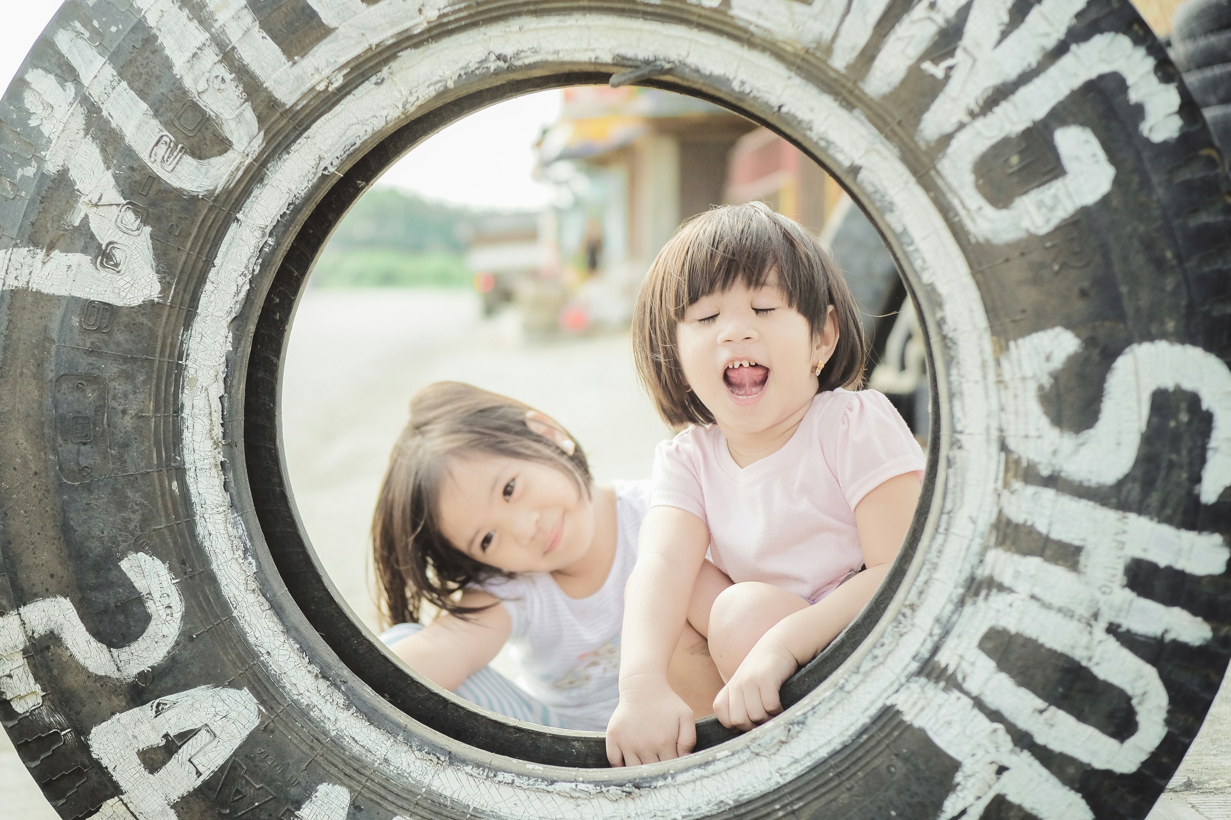 Zwei kleine Mädchen, die in einem Reifen sitzen