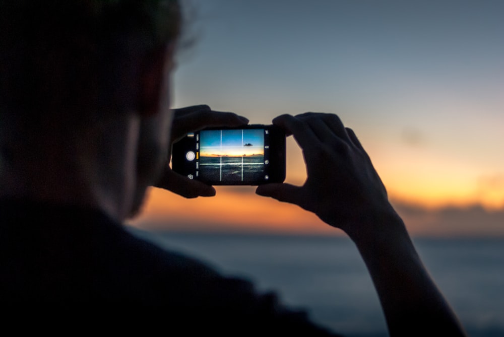 person taking photo of ocean