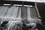 A detailed close-up of a dam’s concrete face with water cascading down.