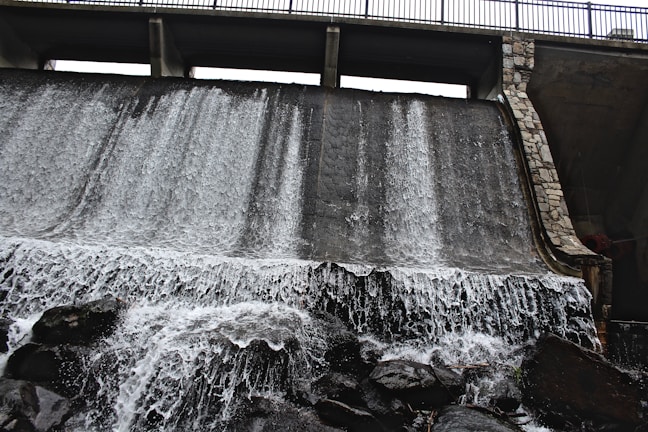 A detailed close-up of a dam’s concrete face with water cascading down.
