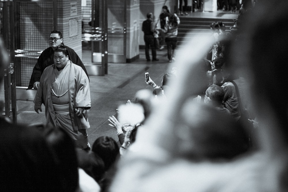 grayscale photography of man walking on aisle