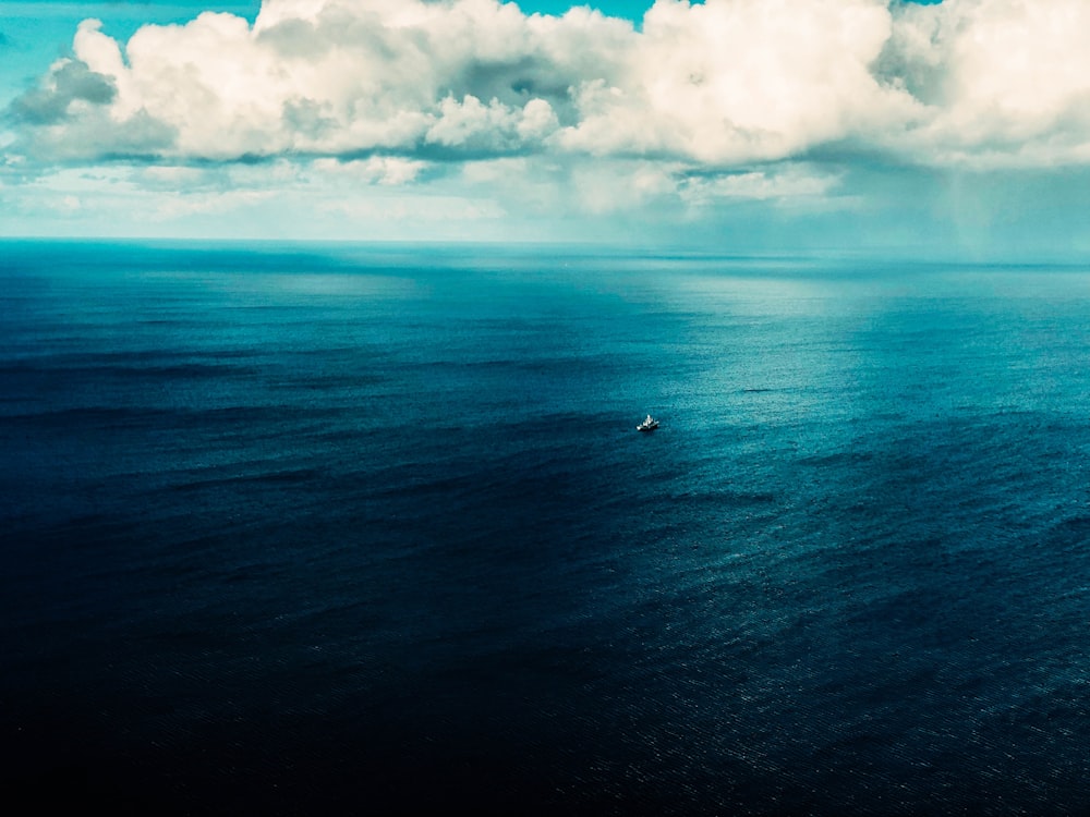 body of water under white clouds