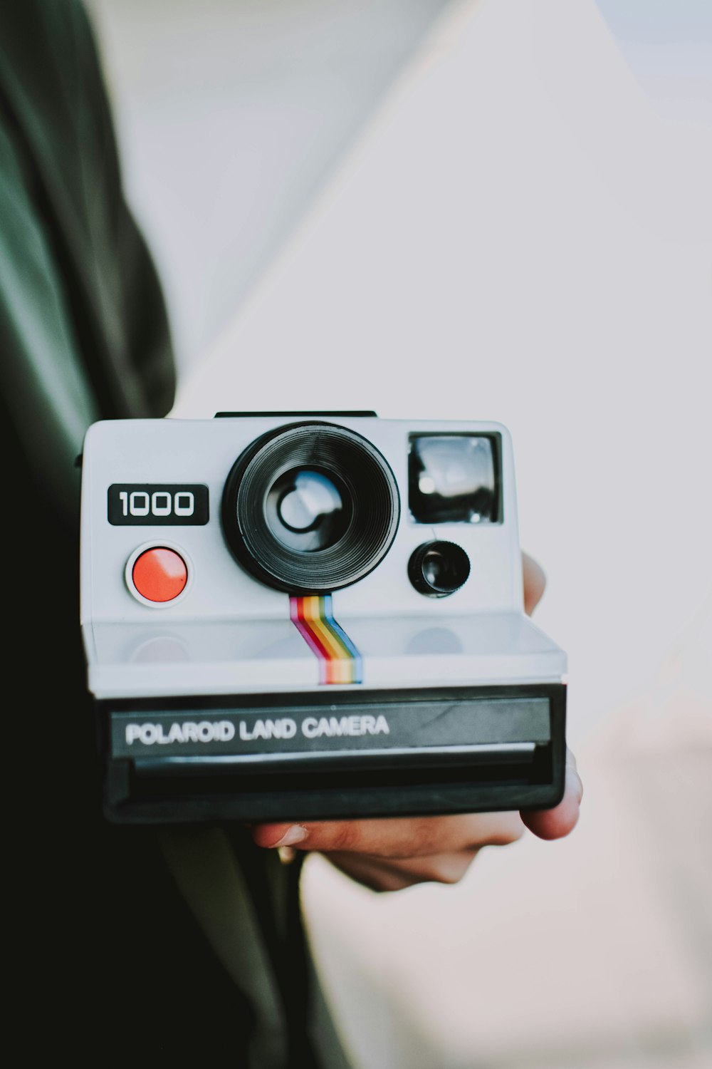 person holding black and white Polaroid land camera