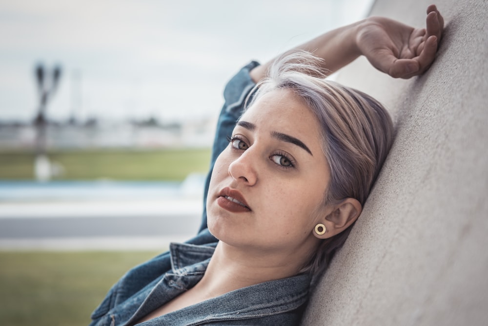 woman leaning on brown wall