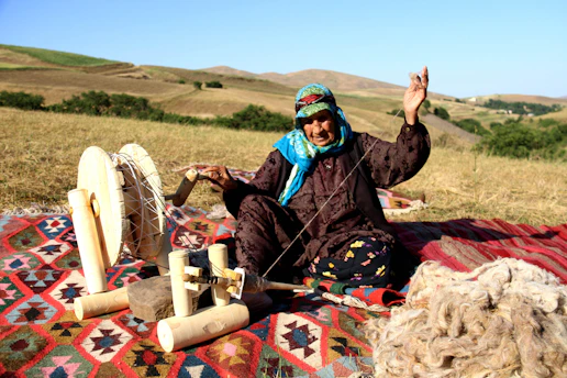 woman using spinning wheel on crop field