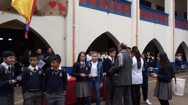 Students gathered around a colorful school event calendar on a bulletin board.