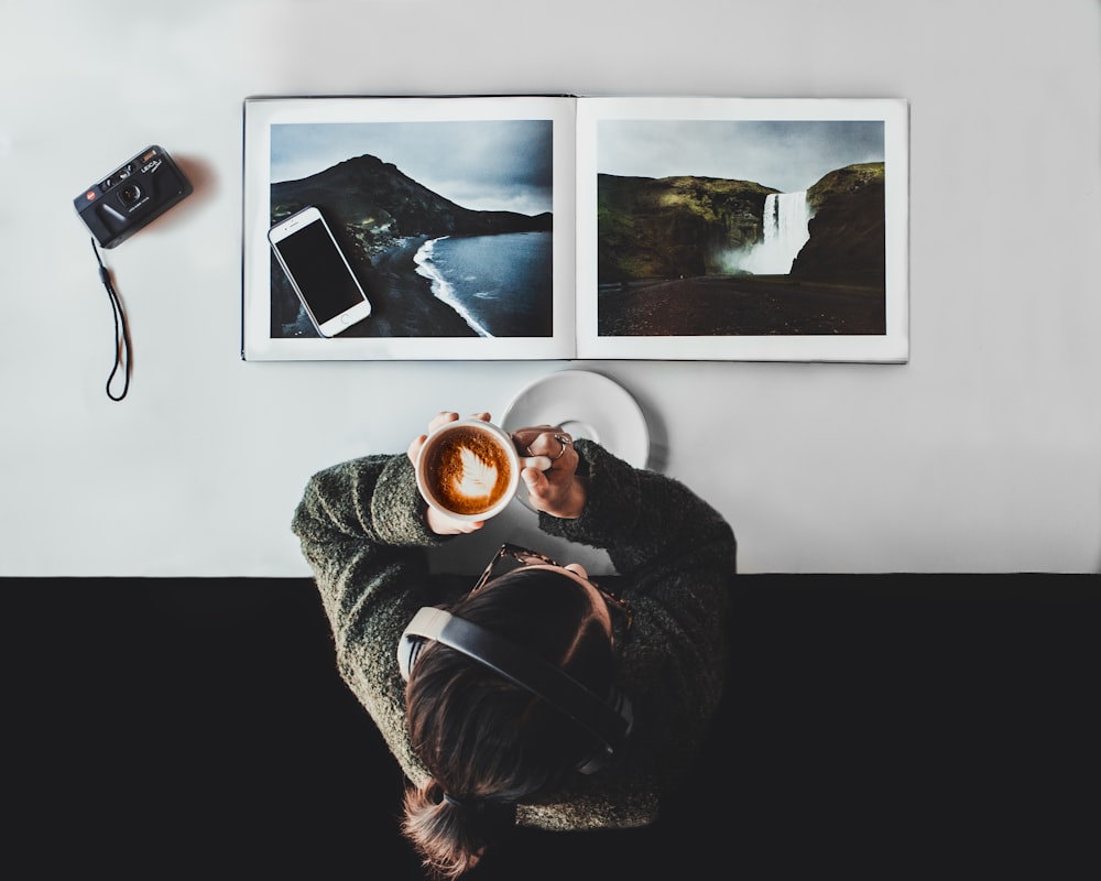 person drinking coffee white listening to headphones