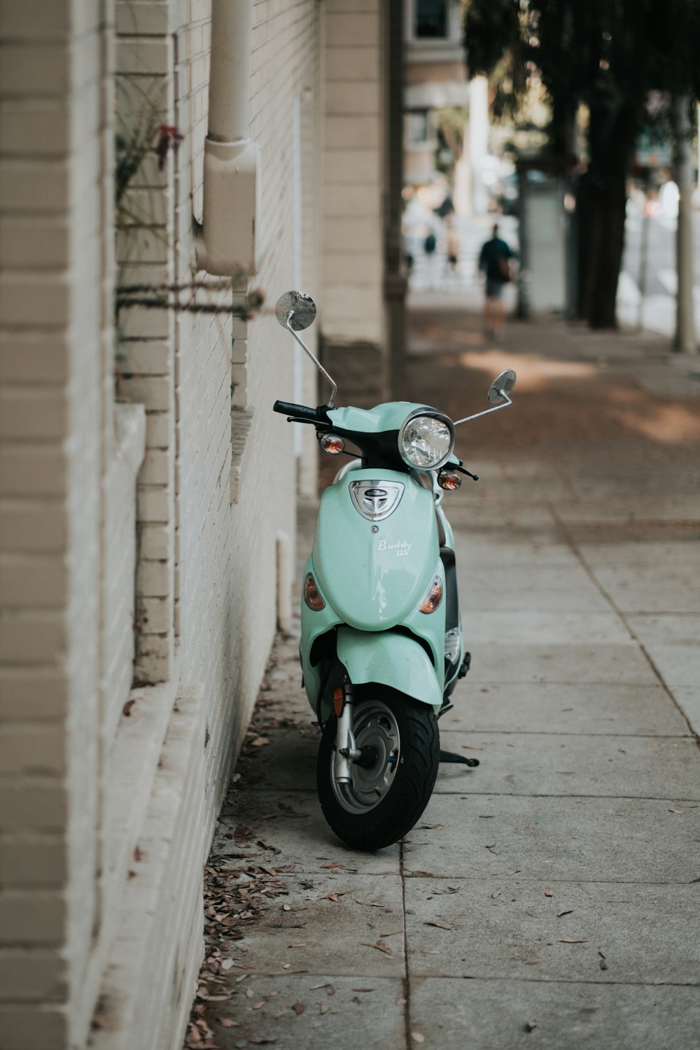 light-blue motor scooter parked near wall