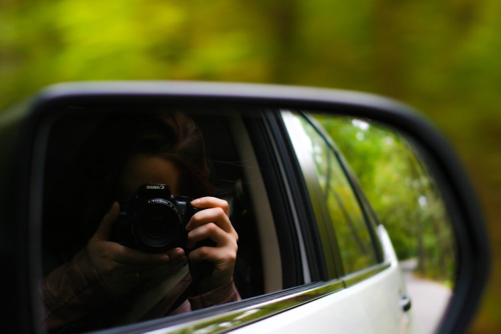 person taking pictures inside vehicle during daytime