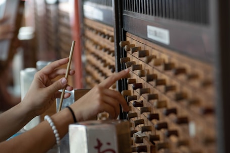 Hands carefully arranging traditional Japanese boxes symbolizing structured finance management.