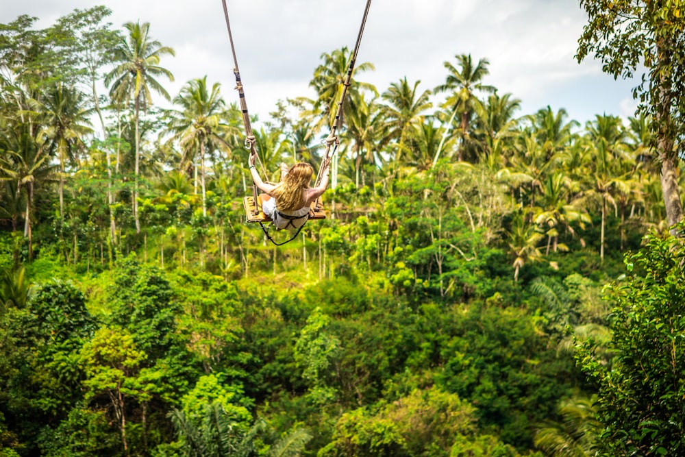 woman doing zipline above trees