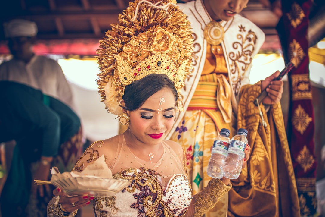 woman wearing brown headdress holding bottled water