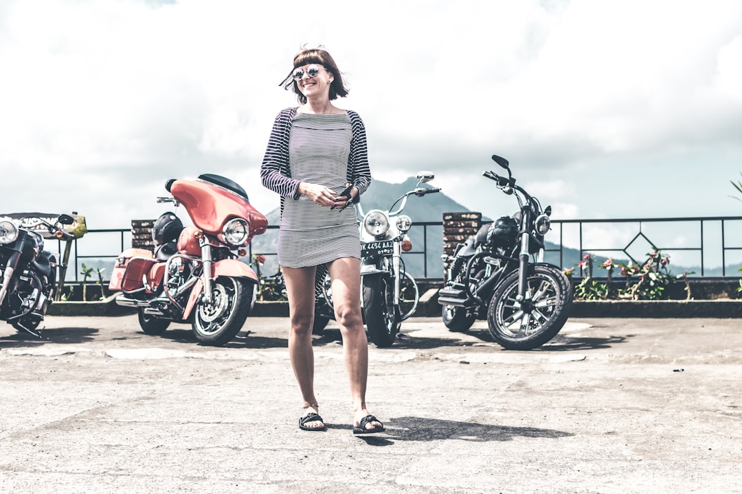 smiling woman standing in front of motorycles