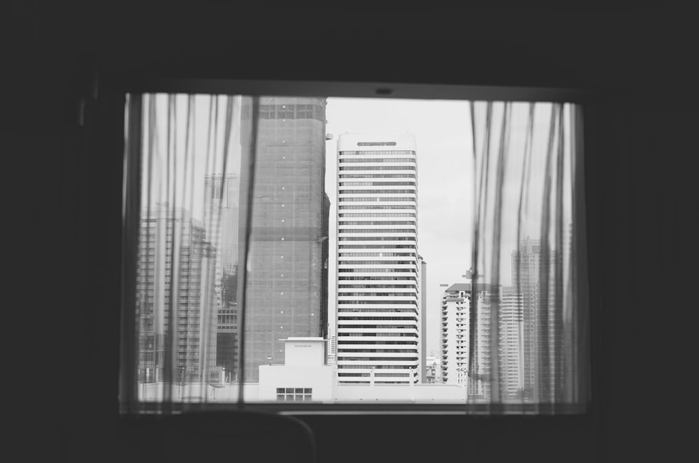 grayscale photography of curtains hanging on open window