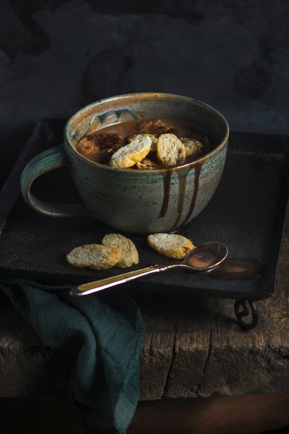 green and brown ceramic teacup and spoon on tray