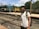 Smiling middle-aged Indian man with a backpack, standing at a train station platform.