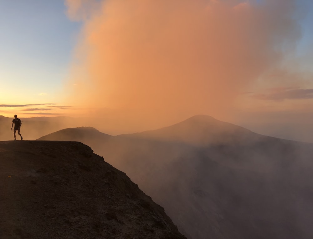 Silhouette eines Mannes, der auf einer Klippe steht