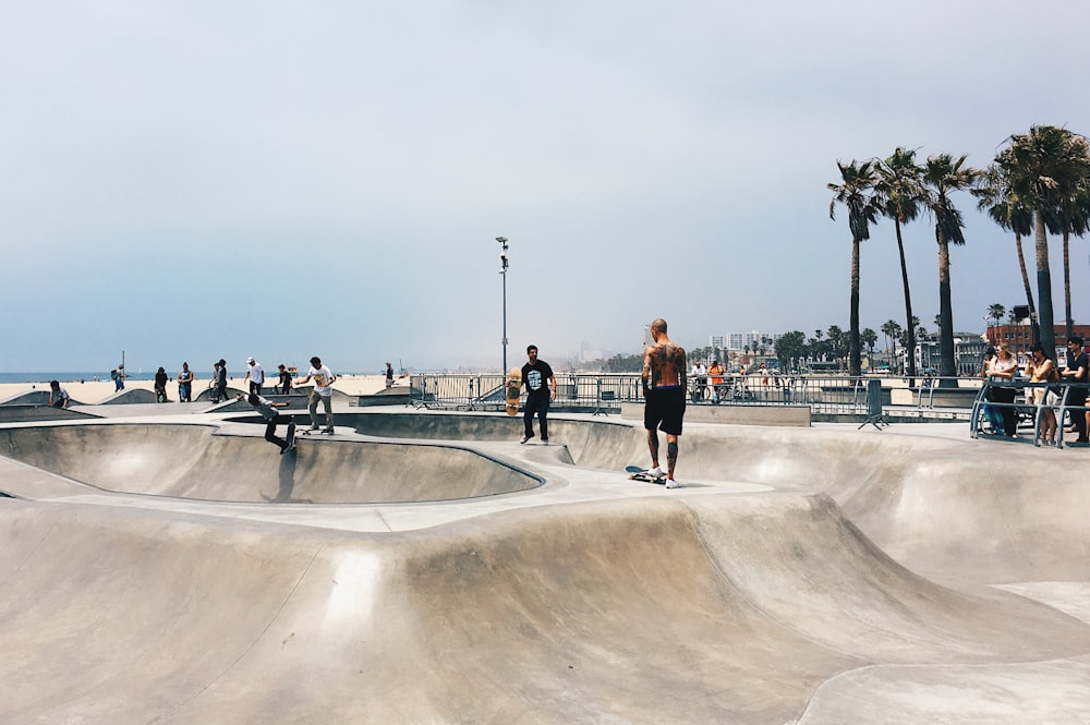 pessoas jogando skate no parque durante o dia.