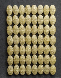 Close-up of Orygenes patches and tablets arranged on a sleek black surface