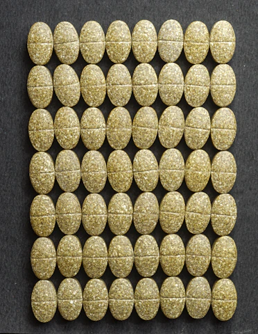 Close-up of Orygenes patches and tablets arranged on a sleek black surface