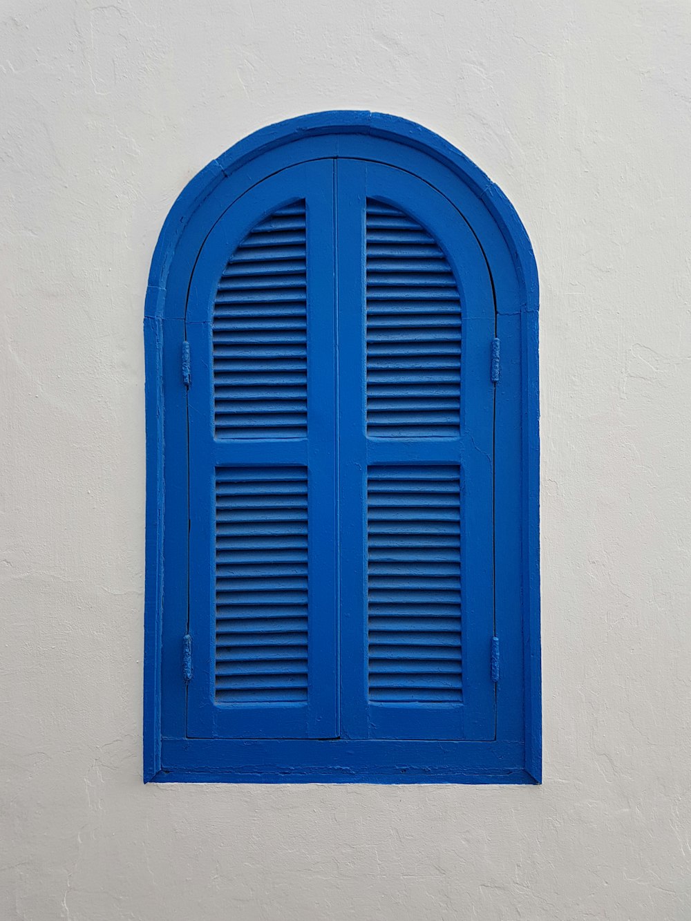 janela de madeira azul na parede