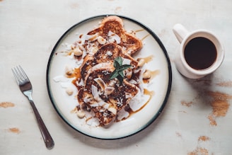 A vibrant plate of tropical French toast topped with fresh fruits, passionfruit, and a dusting of chocolate soil.