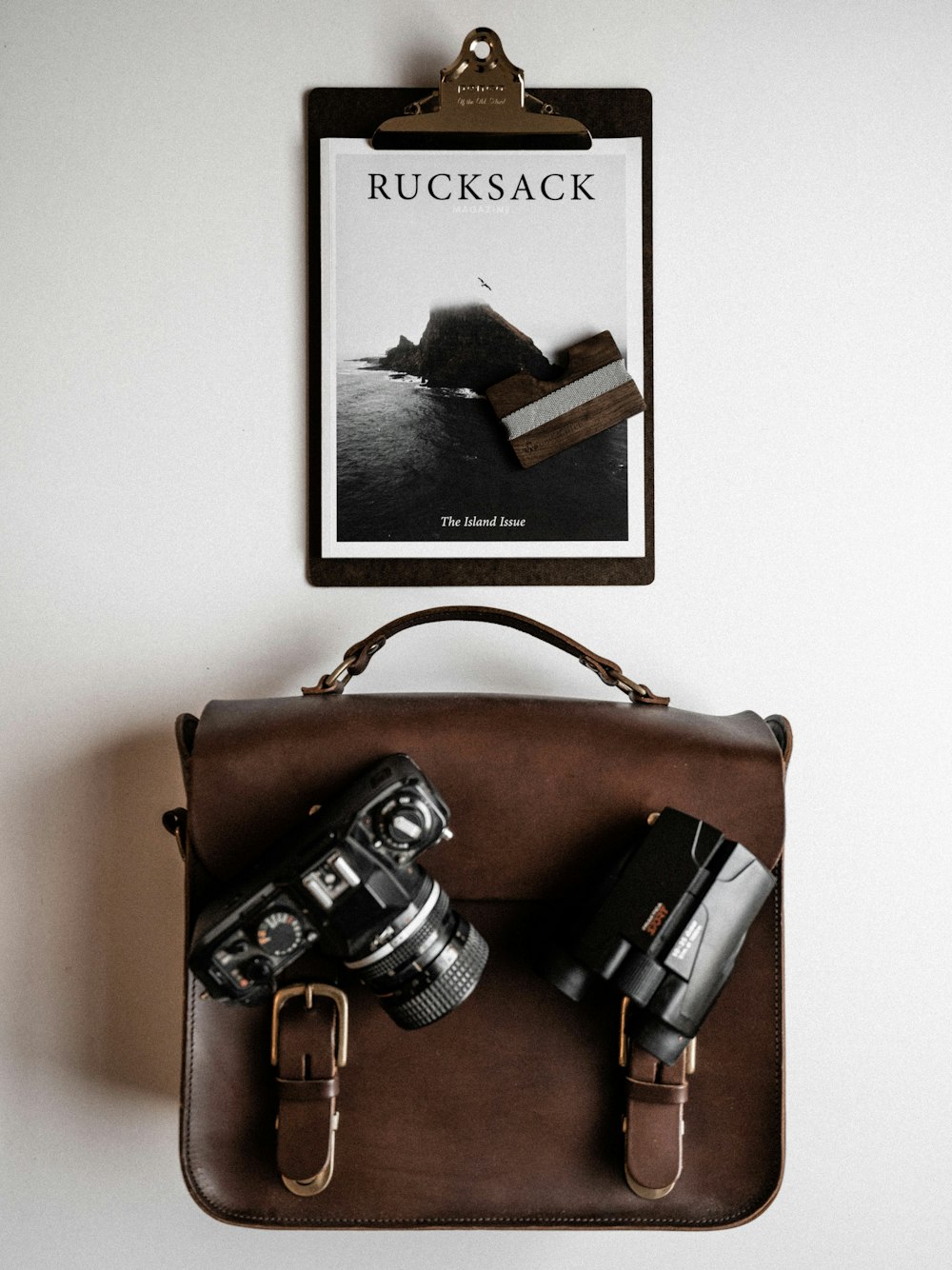 Cartão de papel Rucksack e câmera DSLR em cima do saco