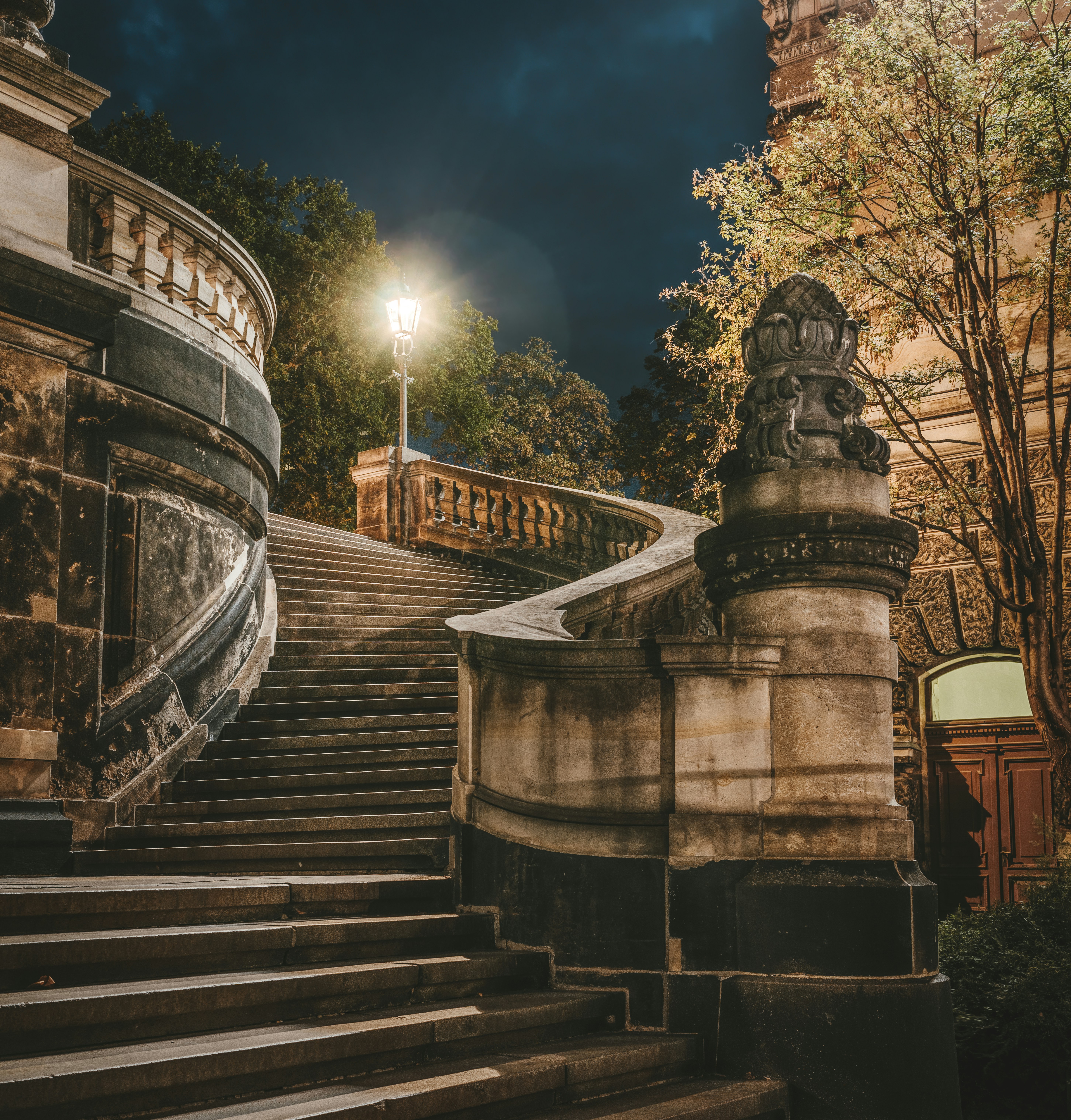 black and brown manor staircase under dark sky