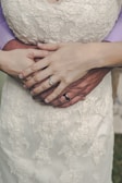 Close-up of intertwined hands with wedding rings shining