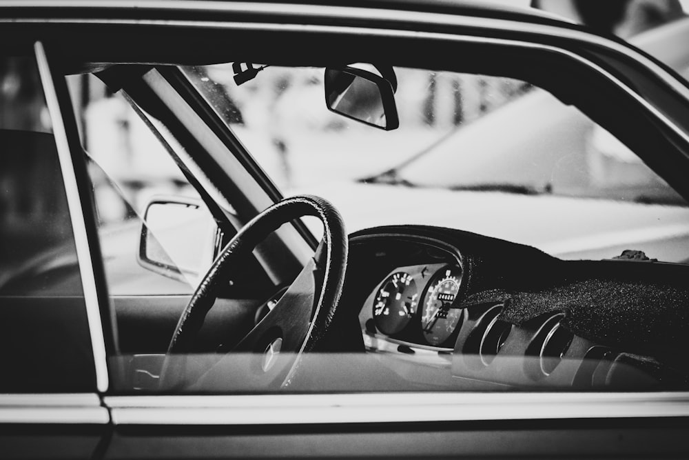 grayscale photo of man in car