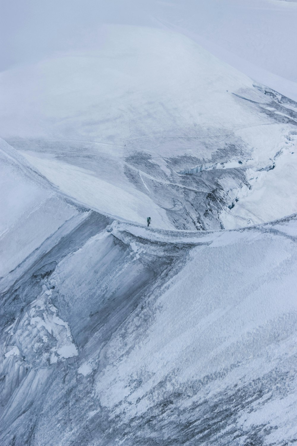 a person riding skis on top of a snow covered slope