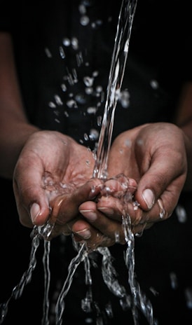 pouring water on person's hands