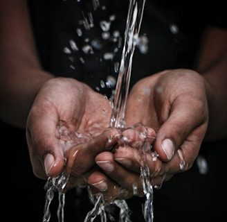 pouring water on person's hands