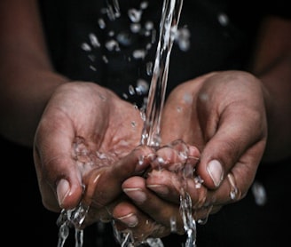 pouring water on person's hands