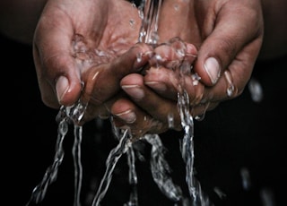 pouring water on person's hands