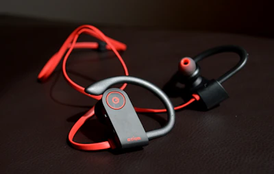 Sporty earphones with ear hooks displayed on a vibrant gym bag